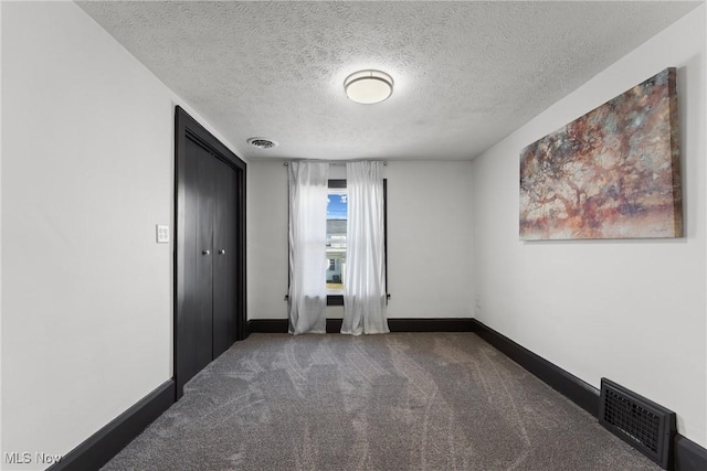 unfurnished bedroom featuring carpet flooring, baseboards, visible vents, and a textured ceiling