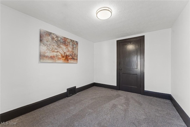 carpeted empty room with visible vents, a textured ceiling, and baseboards