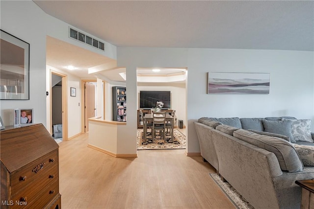 living area featuring visible vents, baseboards, and light wood-style flooring