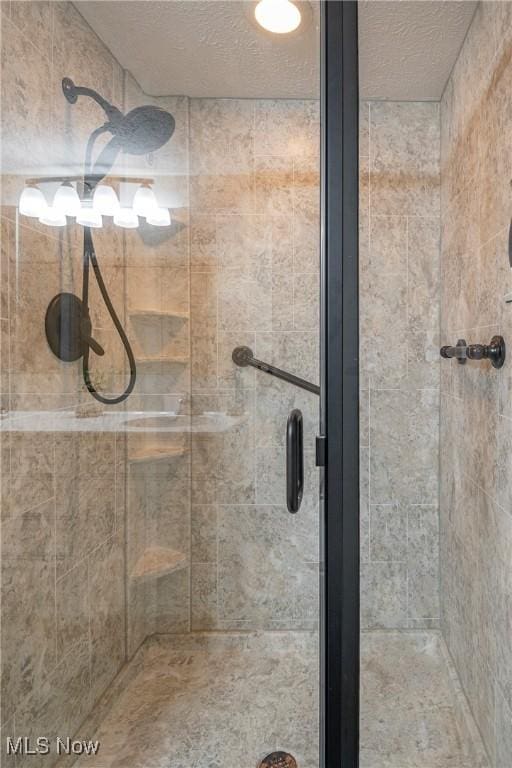 bathroom featuring a textured ceiling and a shower stall