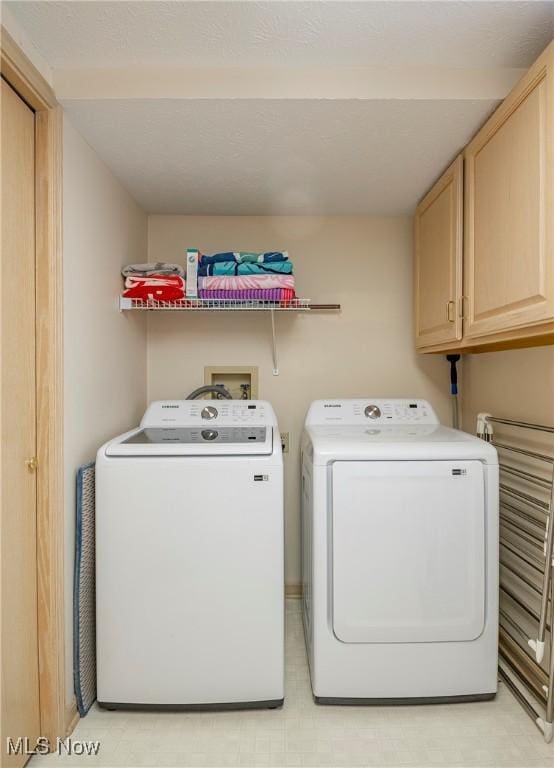 laundry area featuring cabinet space, washer and dryer, and light floors