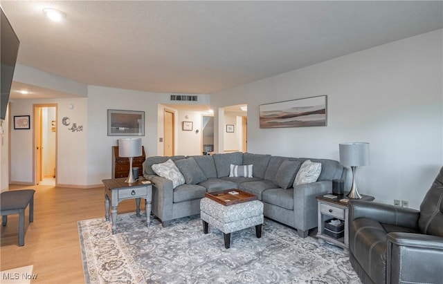 living area featuring visible vents, baseboards, and light wood-style flooring