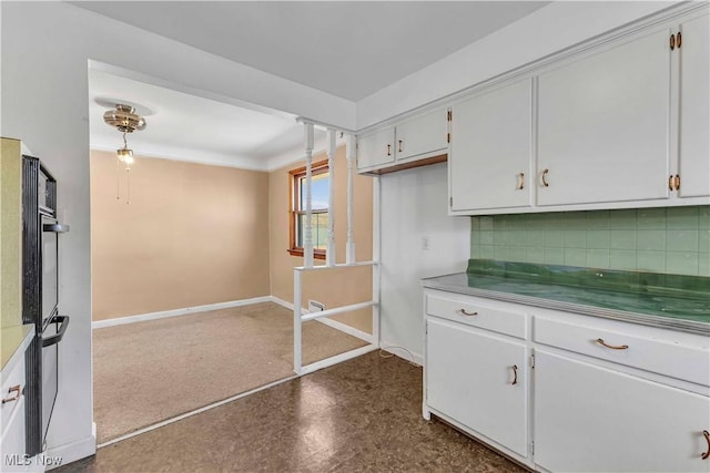 kitchen featuring white cabinetry, decorative backsplash, baseboards, and dobule oven black