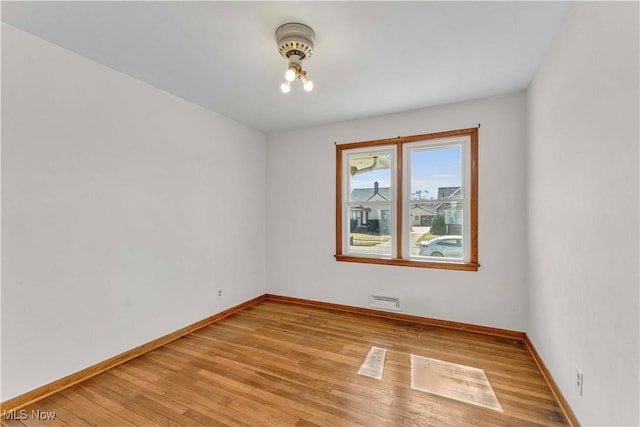 empty room featuring baseboards and light wood-style floors