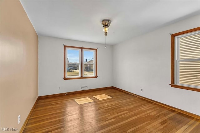 unfurnished room featuring baseboards and wood finished floors