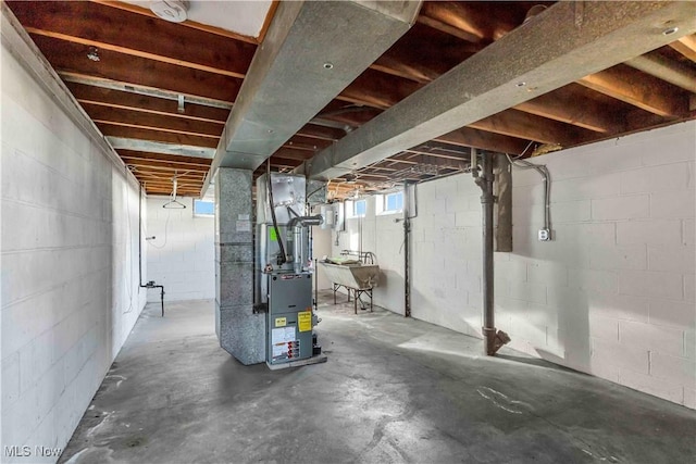 basement with heating unit and a sink