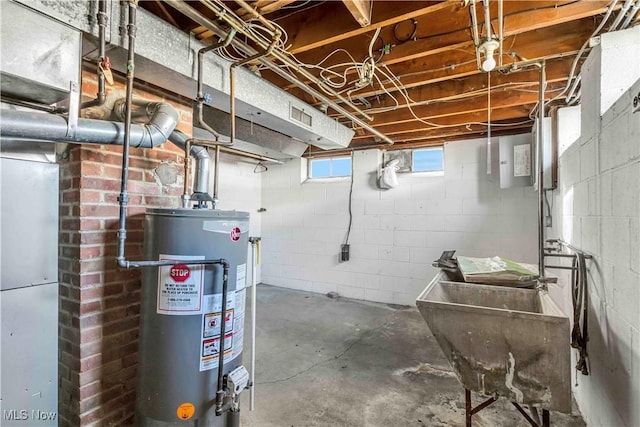 below grade area featuring gas water heater, visible vents, and a sink