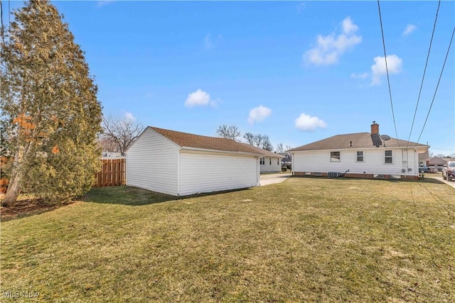 back of property with a lawn and fence