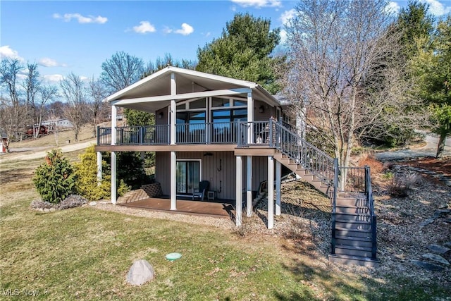 back of property featuring stairway, a lawn, and a wooden deck