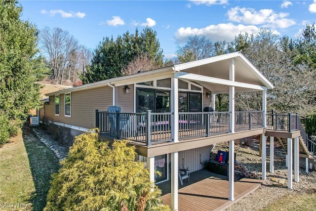 rear view of house with stairway, cooling unit, and a wooden deck