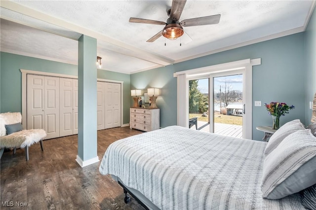 bedroom featuring baseboards, dark wood-style flooring, ceiling fan, multiple closets, and access to outside