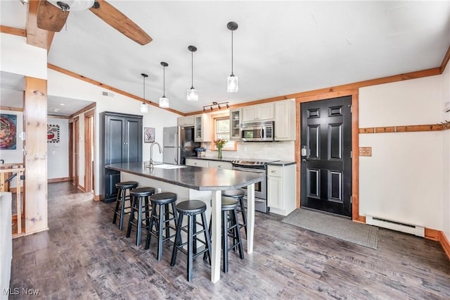 kitchen with dark countertops, a breakfast bar, vaulted ceiling, stainless steel appliances, and a baseboard radiator