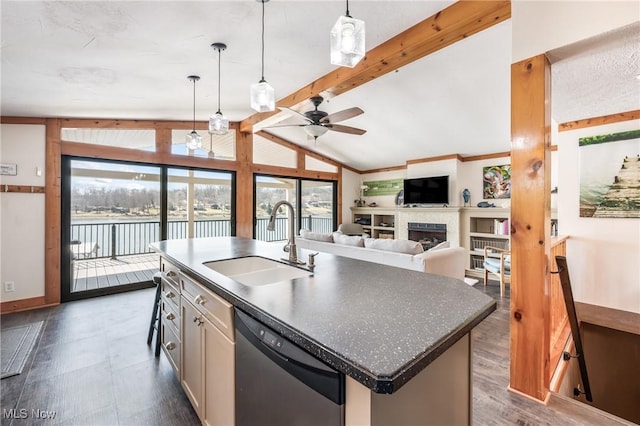 kitchen with a sink, lofted ceiling with beams, dark countertops, a fireplace, and dishwasher