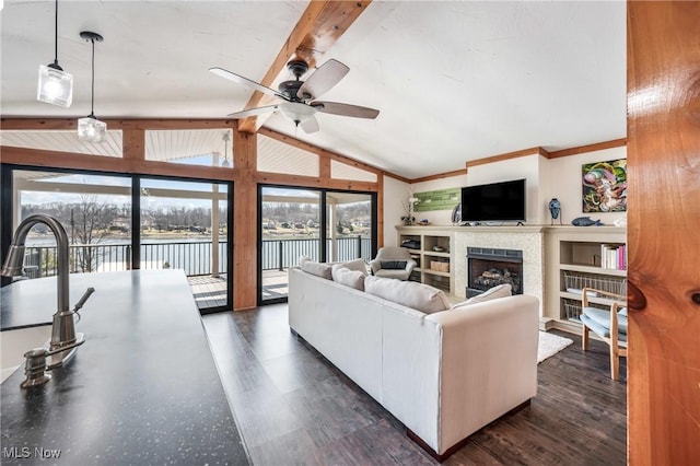 living area featuring a ceiling fan, lofted ceiling with beams, a fireplace, and dark wood-type flooring