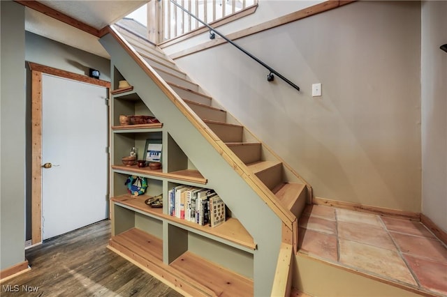 stairway featuring baseboards and wood finished floors