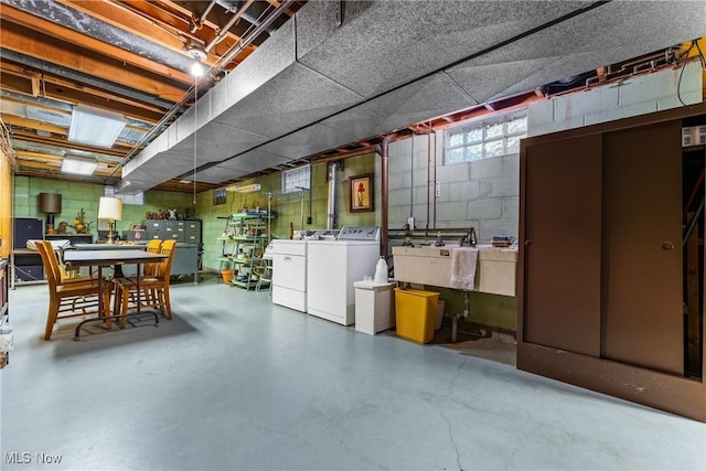 basement with washer and dryer, concrete block wall, and a sink