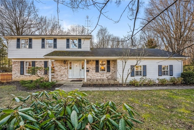 view of front of house with brick siding and fence