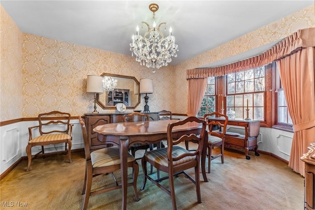 dining room featuring wallpapered walls, a notable chandelier, light colored carpet, and baseboards