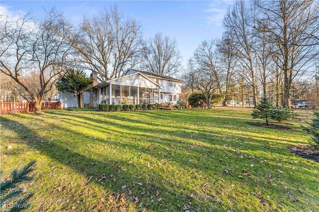 view of yard with fence and a sunroom