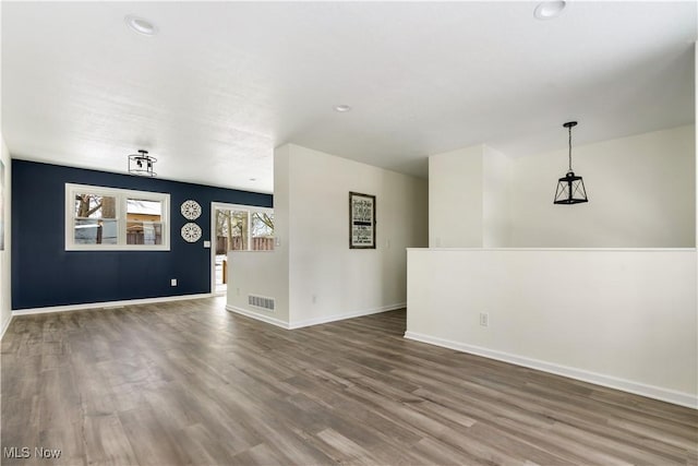 unfurnished living room featuring recessed lighting, wood finished floors, visible vents, and baseboards