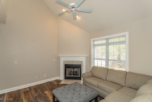 living room featuring ceiling fan, baseboards, a fireplace, wood finished floors, and high vaulted ceiling