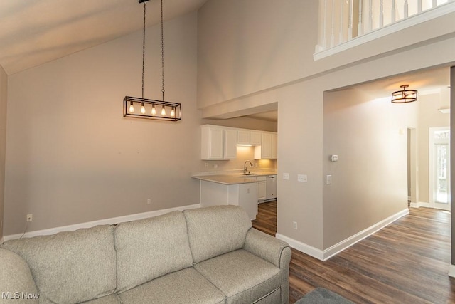 living room with baseboards, dark wood-type flooring, and high vaulted ceiling