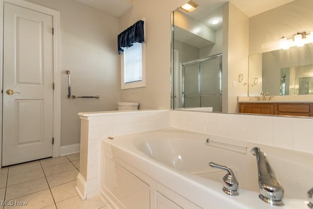 bathroom with tile patterned flooring, toilet, a garden tub, a stall shower, and vanity