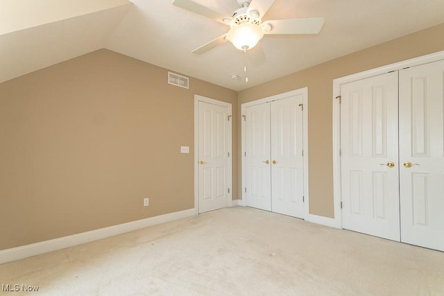 unfurnished bedroom featuring visible vents, baseboards, two closets, and light colored carpet