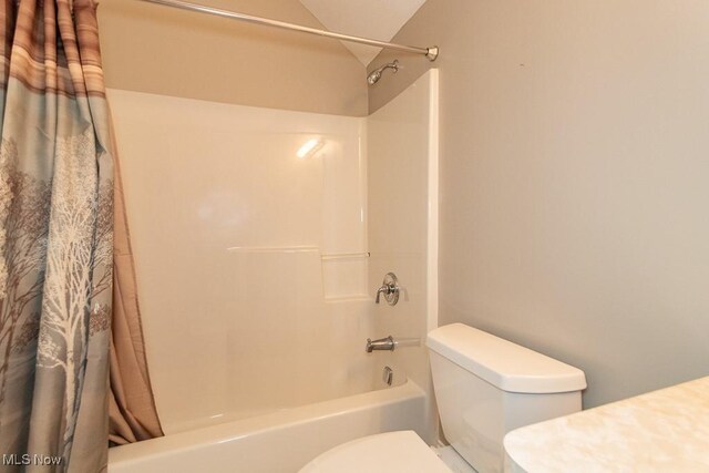 full bath featuring toilet and shower / bath combo with shower curtain