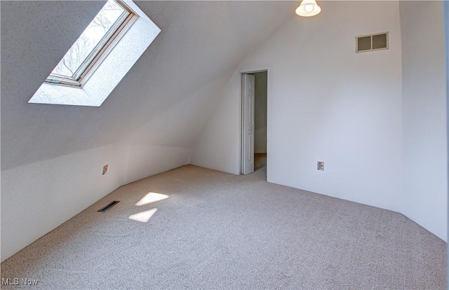 bonus room with lofted ceiling, carpet flooring, and visible vents