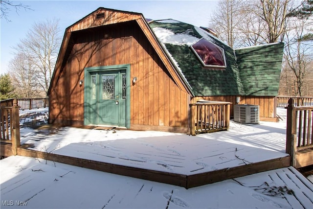 snow covered structure with central AC unit