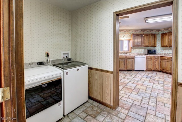 washroom with washing machine and clothes dryer, laundry area, and wallpapered walls