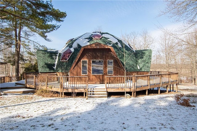 view of front of property featuring a deck and a shingled roof