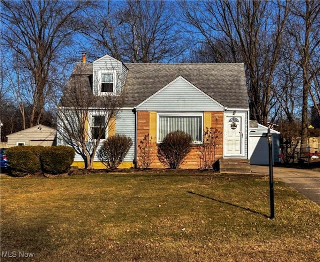 cape cod home with a chimney, roof with shingles, and a front lawn