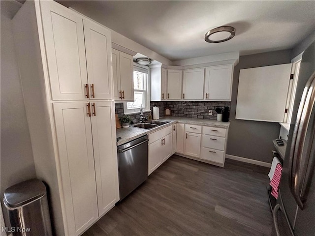 kitchen featuring dark wood finished floors, white cabinets, stainless steel appliances, and a sink