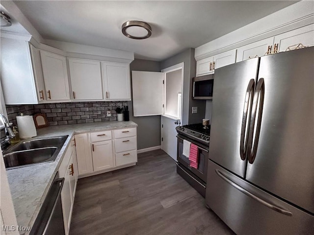 kitchen featuring a sink, stainless steel appliances, backsplash, and white cabinetry