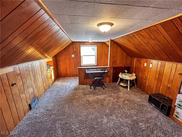 bonus room with wood walls, lofted ceiling, and carpet