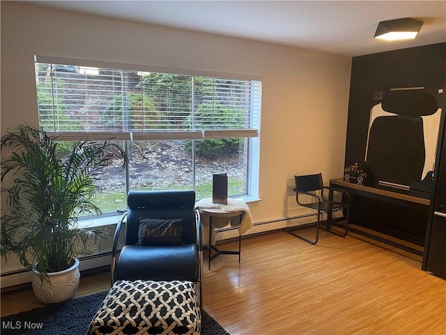 sitting room featuring wood finished floors and baseboard heating