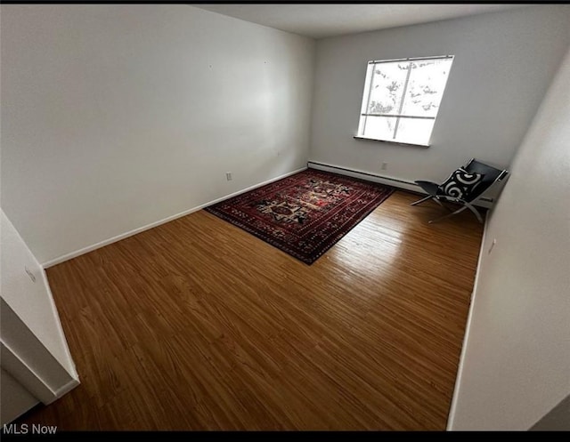 interior space with wood finished floors, baseboards, and a baseboard radiator