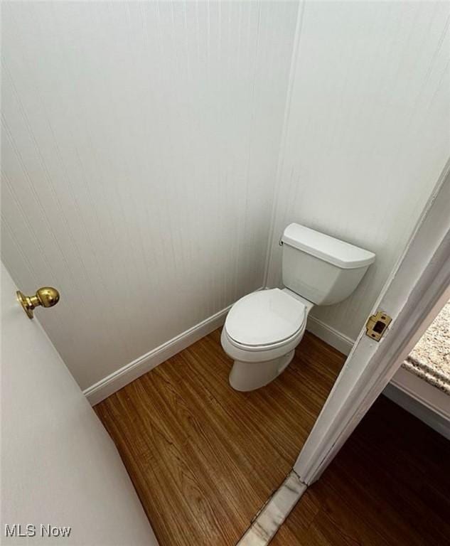 bathroom featuring baseboards, toilet, and wood finished floors