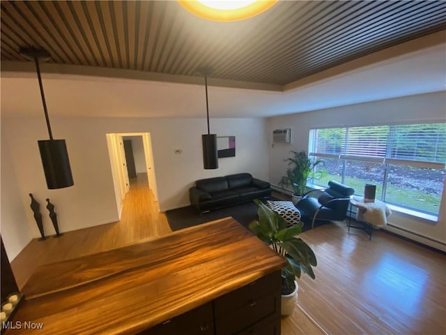 living room featuring a wall unit AC and wood finished floors