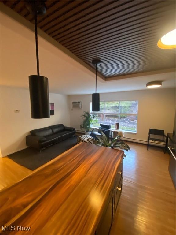 unfurnished dining area featuring wood finished floors and a wall unit AC