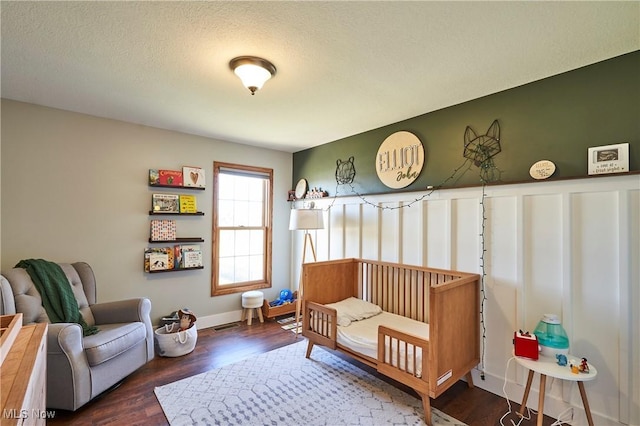 bedroom featuring visible vents, a textured ceiling, and wood finished floors