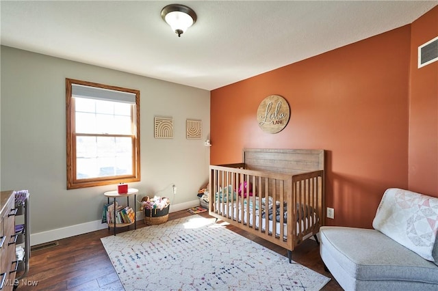 bedroom with visible vents, dark wood-style floors, and baseboards