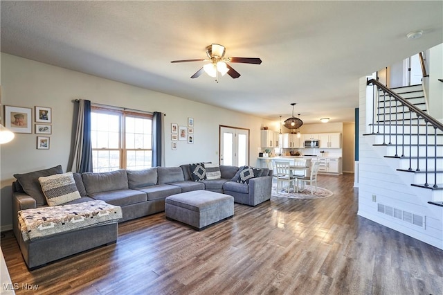 living room with dark wood finished floors, stairway, a ceiling fan, and visible vents