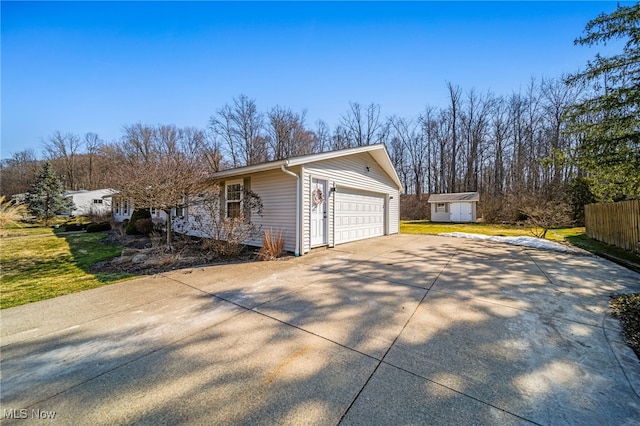 view of side of home with an outbuilding, a storage shed, a garage, and fence