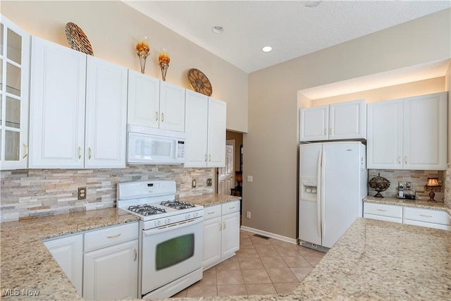 kitchen featuring light tile patterned flooring, white cabinets, and white appliances