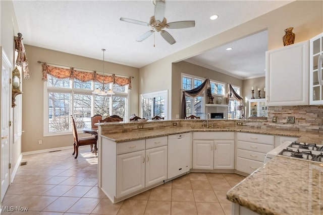 kitchen with dishwasher, white cabinets, light tile patterned floors, and a sink