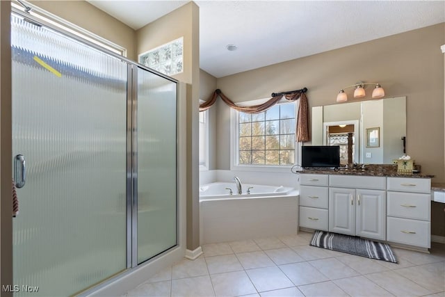 full bath featuring vanity, a garden tub, a stall shower, and tile patterned flooring