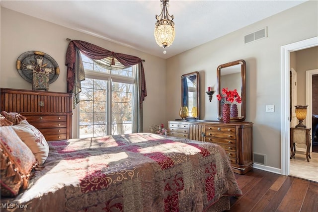 bedroom with dark wood-type flooring, baseboards, and visible vents